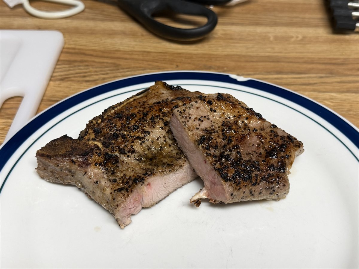 Sliced bone-in pork chop cooked sous vide at 140°F for 2 hours, showing a seared exterior and juicy pink interior